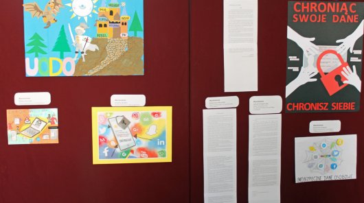 Zdjęcie przedstawia tablicę prezentującą nagrodzone prace w konkursie Twoje dane – Twoja sprawa – 5 prac plastycznych i 3 opowiadania