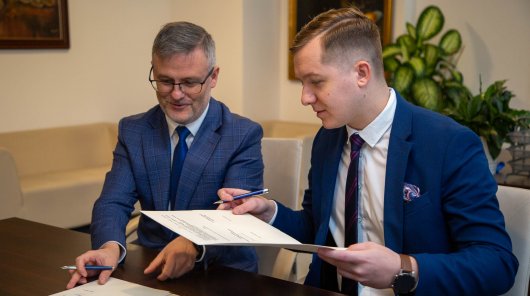 Zdjęcie przedstawiające od lewej: Marcina Wójtowicza, Dyrektora Generalnego GIF oraz Jakuba Groszkowskiego, Zastępcę Prezesa UODO podczas podpisywania porozumienia. Na zdjęciu moment przekazywania sobie egzemplarzy porozumienia. 