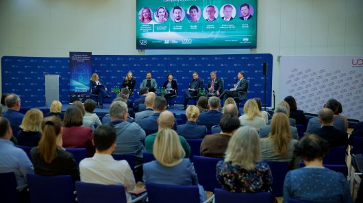 Zdjęcie przedstawiające prelegentów konferencji ZUS w trakcie dyskusji. W tle licznie zgromadzona, siedząca na krzesłach publiczność/