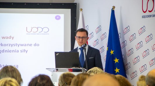 Zdjęcie przedstawiające dyr. Departamentu Informatyki UODO, przy mównicy, przemawiającego w trakcie konferencji.